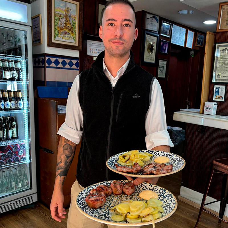 Camarero sirviendo una tapa tradicional en Casa Torcuato