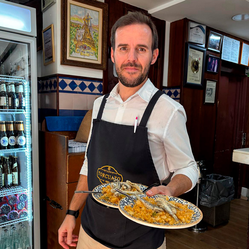 Camarero sirviendo tapas en el restaurante Casa Torcuato